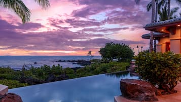 A pool with a view of the ocean and a sunset.