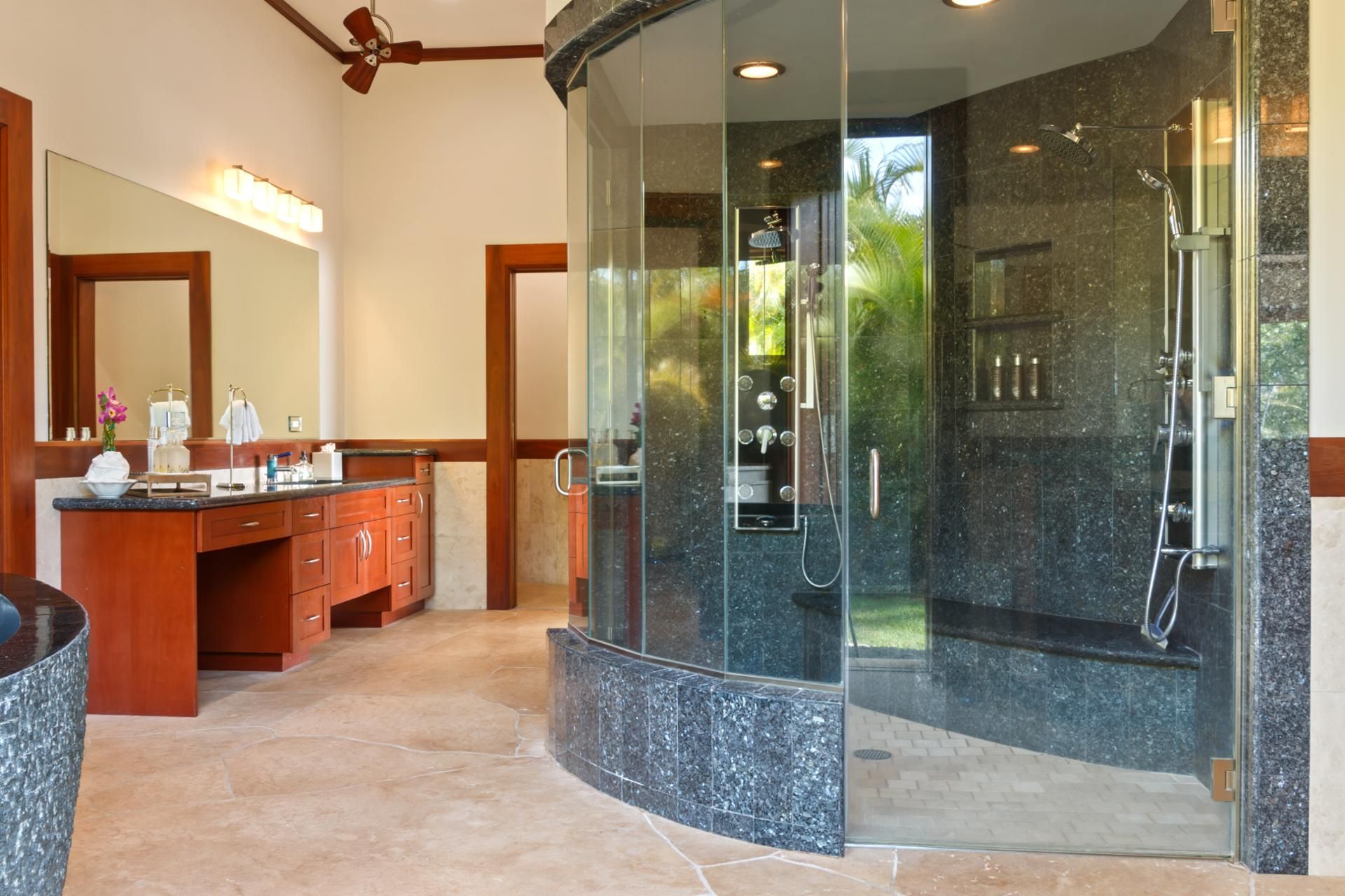 A modern bathroom with a glass-enclosed shower, a vanity with a mirror, and a sink.