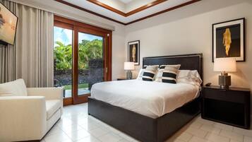Habitación de hotel con una cama grande, un sofá, una mesita de noche y vistas a zonas verdes.