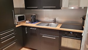 A modern kitchen with a microwave, coffee maker, and stainless steel appliances. - Apartment Aelpli by Interhome (Grindelwald)