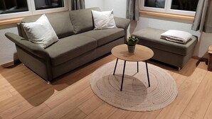 A living room with a sofa, a small coffee table, and a rug. - Apartment Aelpli by Interhome (Grindelwald)