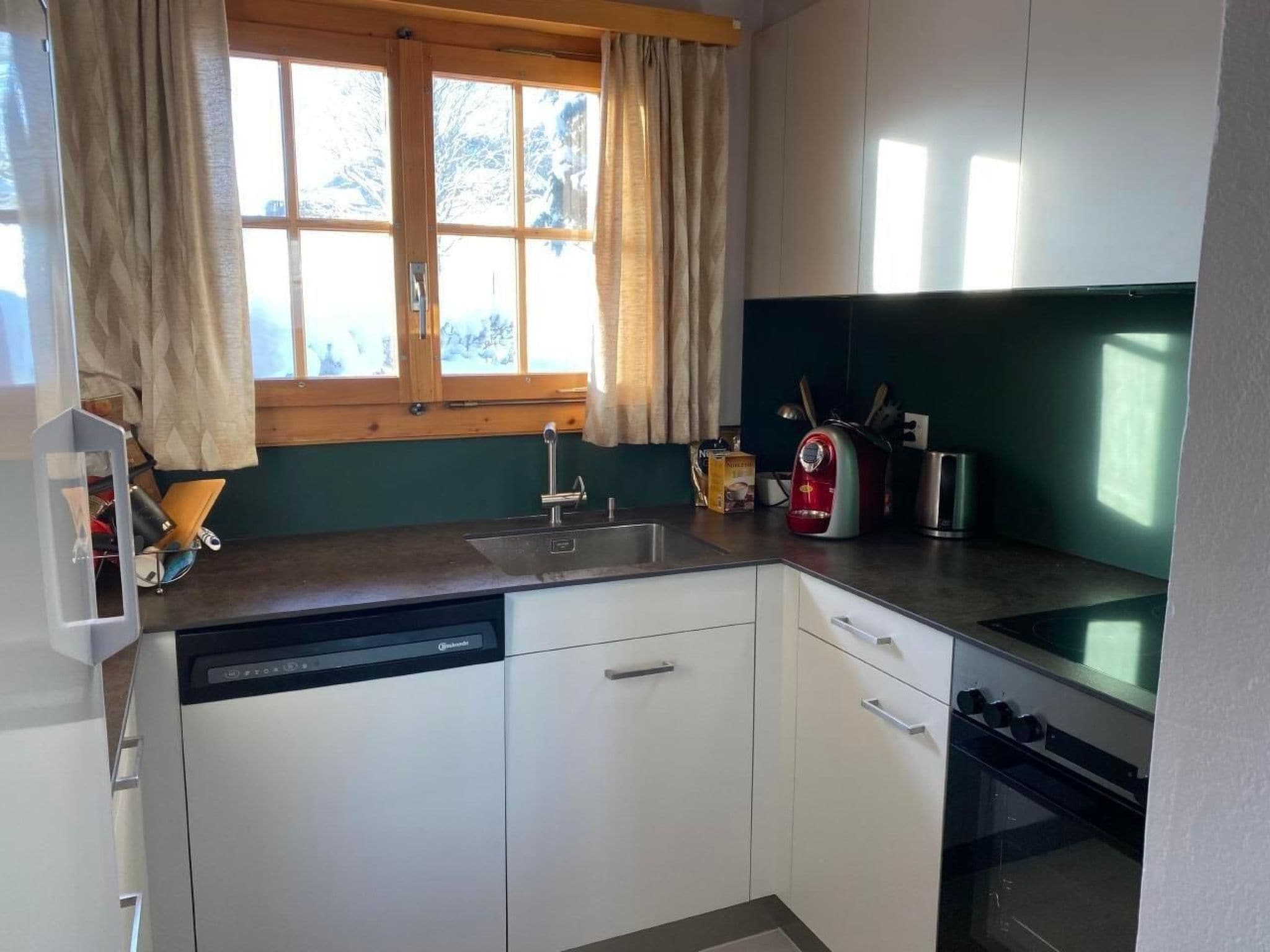 A compact kitchen with a dishwasher, a sink, and a stove.