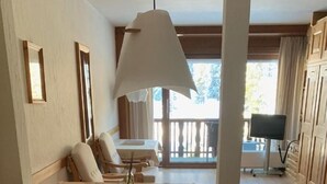 Un coin repas chaleureux avec une table en bois, des chaises et une lampe suspendue.