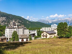 A mountainous town with a prominent building featuring multiple windows and a distinct tower. - Chesa Kober - adults only by Interhome (Pontresina)
