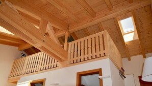 Ein Holzinnenraum mit Balkon, zwei Türen und einem Fenster.