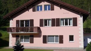 Ein zweistöckiges Gebäude mit Balkon, mehreren Fenstern und der Aufschrift 'Suot God' an der Fassade.
