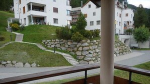 On voit un hôtel avec un mur de soutènement en pierre, une pente herbeuse et un chemin pavé menant à l’entrée.