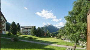 Ein Wohngebiet mit Häusern, einem Rasen, einem Pfad und einem Berg im Hintergrund.