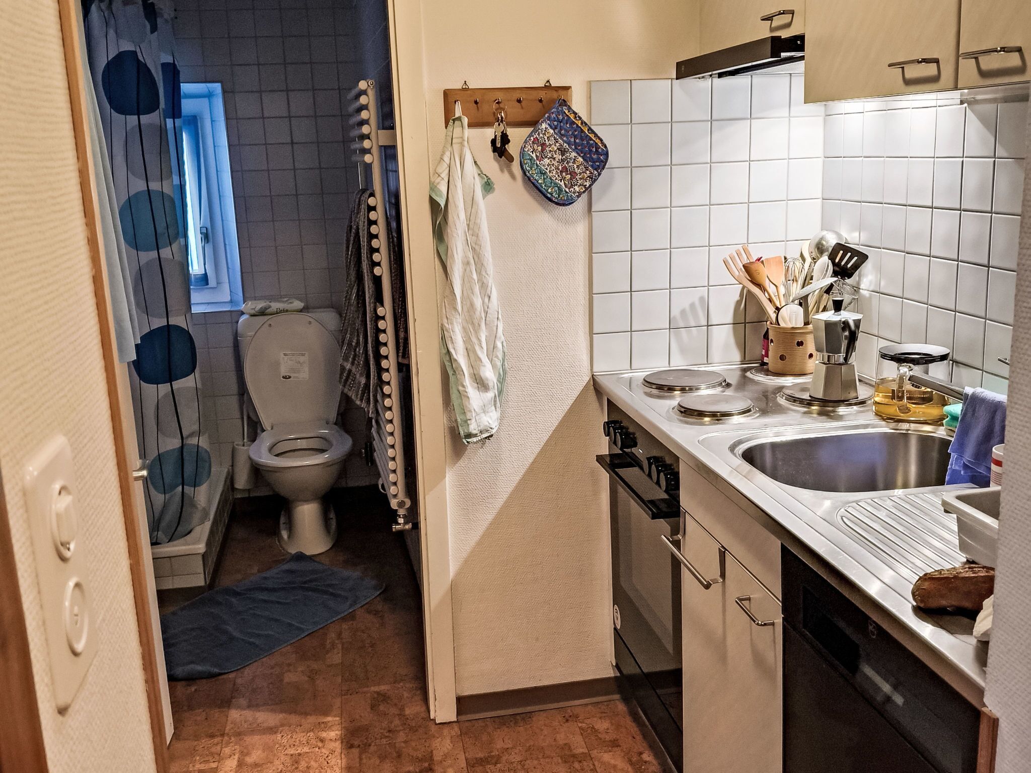 A compact kitchen with a sink, stove, and cabinets.