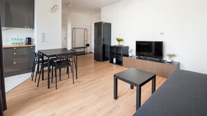 A modern living space with a dining area, kitchen, and entertainment area. - Ursus Spacious Apartment (Warszawa)