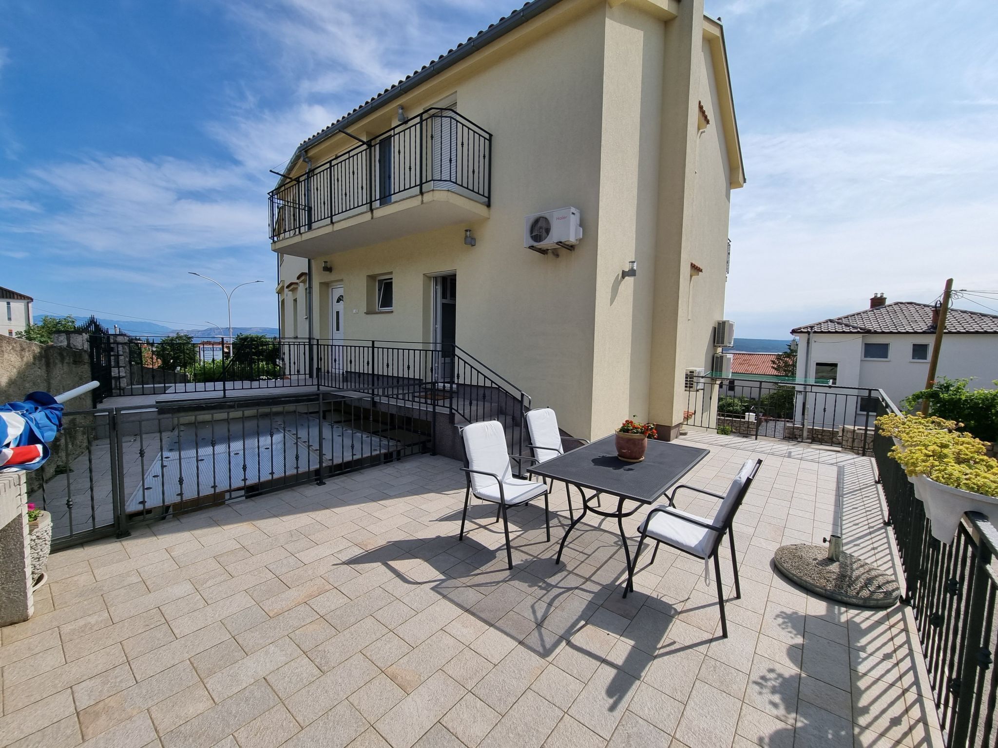 A terrace with a table and chairs, a small balcony, and a view of the sea. - Nina 2 pax by Interhome (Crikvenica)