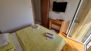 A bedroom with a bed, a desk, a TV, and a window. - Nina 2 pax by Interhome (Crikvenica)