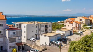 A coastal residential area with modern buildings, a clear blue sea, and distant mountains. - Studio-Apartment mit Balkon und Meerblick by Interhome (Crikvenica)