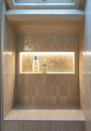 Een badkamer met een ingebouwd plankje voor toiletartikelen.