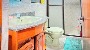 A bathroom with a sink, toilet, and shower area. - Laureles Co-Living Casa 5 habitaciones (Medellín)