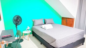A bedroom with a bed, a desk, a chair, a fan, and a small table. - Laureles Co-Living Casa 5 habitaciones (Medellín)