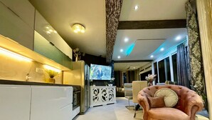 A modern kitchen with white cabinets, a built-in oven, and a TV mounted above the refrigerator. - Schönes Appartement am Strand mit Terrasse by Interhome (Makarska)
