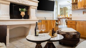 Uma sala de estar aconchegante com lareira, televisão fixada na parede e um espaço de refeições com armários de madeira e uma mesa.