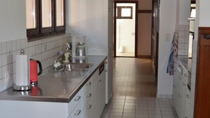 Una cucina moderna con mobili bianchi, un lavello in acciaio inossidabile e una macchina da caffè.