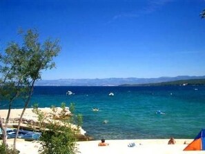 A beach with clear blue water, boats, and a tent. - mit Blick auf das Wasser by Interhome (Krk/Milohnići)