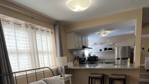 A hotel room with a bed, a small kitchenette, a bathroom, and a view of the city. - Remodeled studio in the heart of  historic downtown Durango! (Durango)