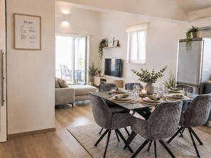 A modern dining area with a table set for four, surrounded by grey upholstered chairs. - Appartement mit Blick auf das Wasser by Interhome (Krk/Milohnići)