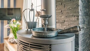 A modern kitchen with a central heating unit, a decorative metal pot, and a kettle on top. - Schwanke´s Feri by Interhome (Gingst)