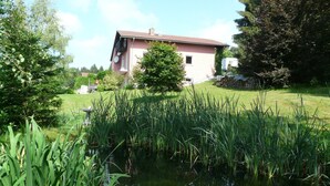 Een huis met een tuin en een vijver.