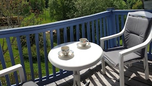 A deck with a white table and two chairs, a cup and saucer on the table, and a blue railing. - Appartement in Langfurth mit Kleinem Balkon by Interhome (Langfurth)