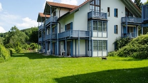 A multi-story building with balconies, a red-tiled roof, and a well-maintained lawn. - Appartement in Langfurth mit Kleinem Balkon by Interhome (Langfurth)