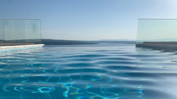 A clear blue infinity pool with a view of distant mountains. - Villa Vespera by Interhome (Crikvenica)