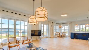 A spacious living room with a large TV, wooden furniture, and a view of the sea. - Villa Vespera by Interhome (Crikvenica)