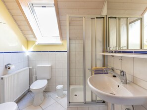 A modern bathroom with a skylight, a shower, a toilet, and a sink. - "Säntisblick" by Interhome (Hergensweiler)