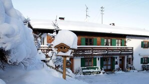 A traditional wooden chalet with green shutters, a balcony, and a snow-covered roof. - FeWo Bärli by Interhome (Bad Bayersoien)