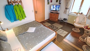 A bedroom with a bed, a dresser, a television, a chair, and a window. - FeWo Bärli by Interhome (Bad Bayersoien)