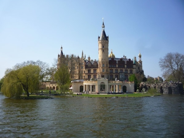 A historic building with a prominent tower, situated by a body of water. - Gemütliches Schwedenhäuschen mit Terrasse by Interhome (Alt Jassewitz)