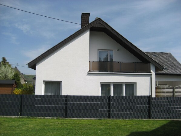 A two-story house with a white exterior, a balcony on the upper floor, and a black fence in front. - in der Vulkaneifel by Interhome (Ulmen)