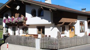 A traditional chalet with a wooden fence, a balcony with flowers, and a clear blue sky. - App. Gabriela by Interhome (Kaltenbach)