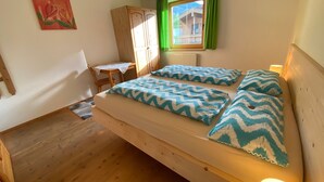 A room with a wooden bed, a desk, and a chair. - App. Gabriela by Interhome (Kaltenbach)