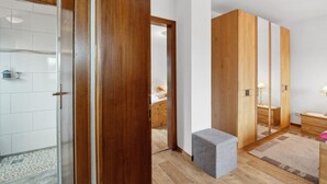 A modern bathroom with a wooden vanity, a mirror, and a shower area. - Haus-Fernblick by Interhome (Mechernich)