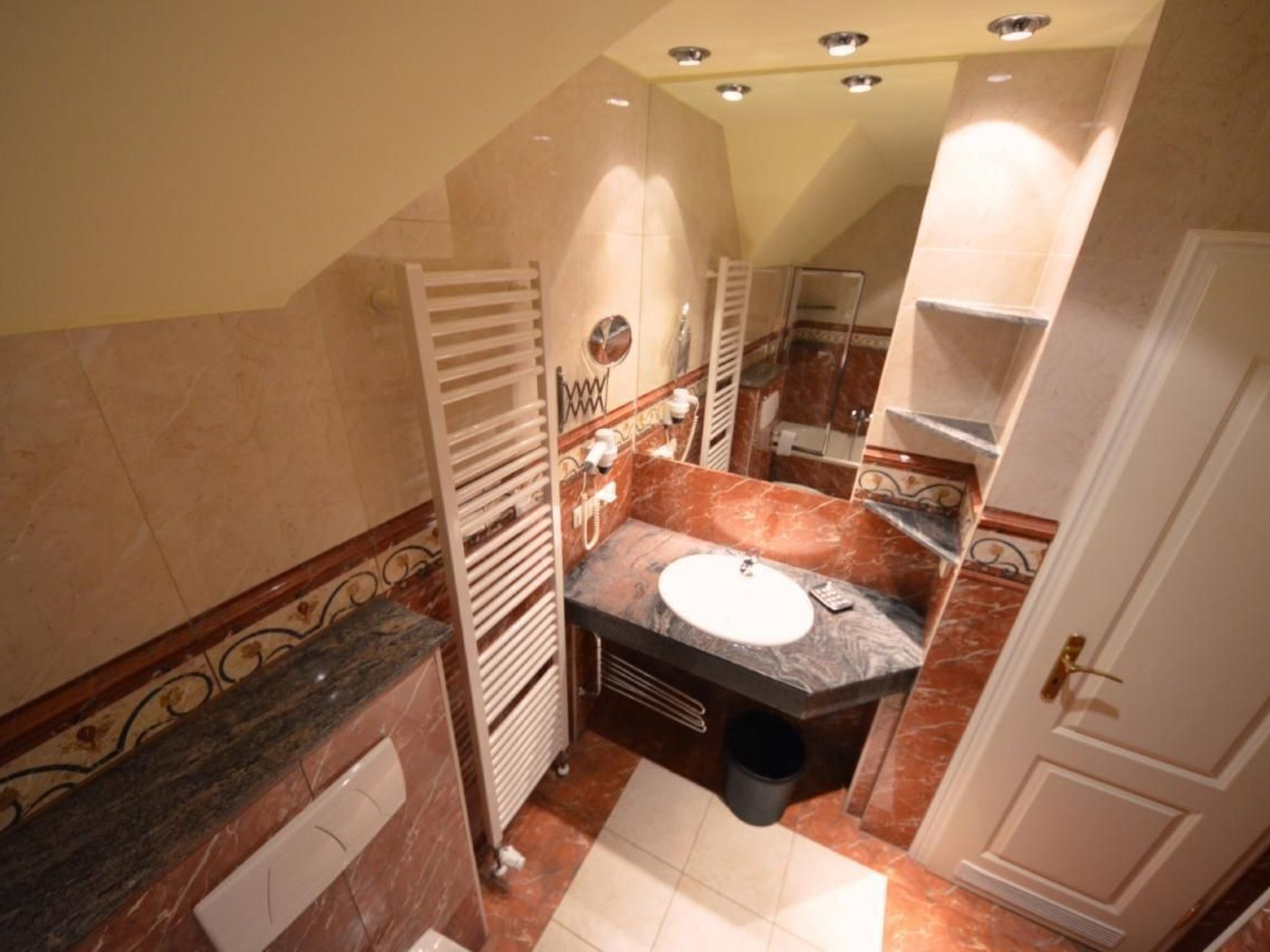 A compact bathroom with a sink, towel rack, and a mirror.