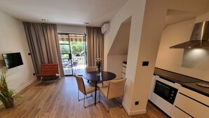 A modern kitchen with a built-in oven and a dining area with a round table and chairs. - VIL Studio-Wohnung in Crikvenica, Kvarner Bucht by Interhome (Crikvenica)