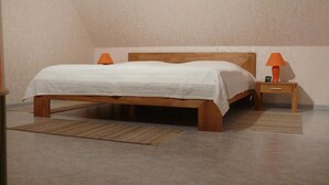 A bedroom with a wooden bed, two bedside lamps, and a small nightstand. - Domizil für zwei by Interhome (Binz)