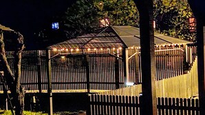 A gazebo with a metal roof and string lights, surrounded by a wooden fence. - Haus Maria Hochschwarzwald, Garten umzäunt, Wald by Interhome (Menzenschwand)