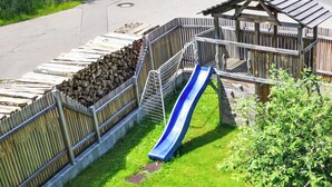 A playground with a slide, a fenced area, and a small building structure. - Haus Maria Hochschwarzwald, Garten umzäunt, Wald by Interhome (Menzenschwand)