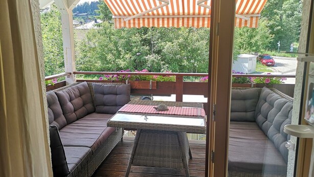 A covered outdoor seating area with wicker furniture and a checkered tablecloth. - Haus Maria Hochschwarzwald, Garten umzäunt, Wald by Interhome (Menzenschwand)