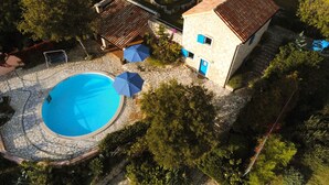 An aerial view of a property with a swimming pool, stone patio, and a small building with a tiled roof. - Ferienvilla Ivanka in Crikvenica by Interhome (Crikvenica)