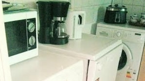 A compact kitchen with a microwave, coffee maker, and a washing machine. - Ferien-Apartment  1 by Interhome (Blankenheim)