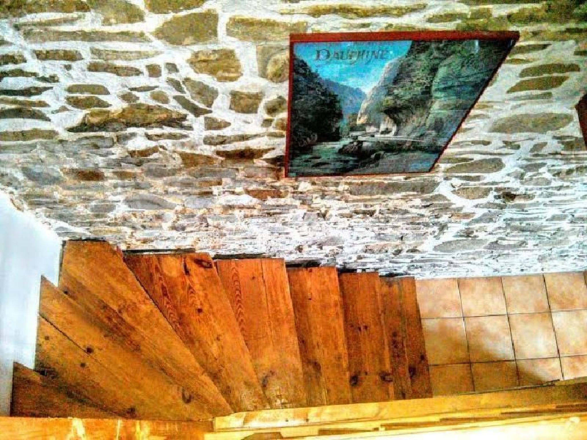 A stone wall with a poster of a waterfall.