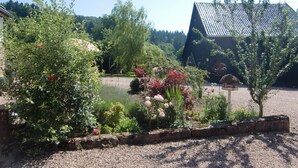 A garden with a variety of plants and a building with a sloped roof. - Little Stonehouse by Interhome (Blankenheim)